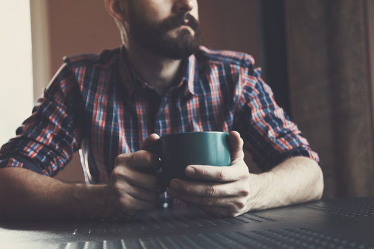 Bearded Man Sitting With Cup Of Morning Coffee Or Tea