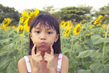 Fototapeta premium Beautiful little girl and sunflower - Vintage Filter Effect