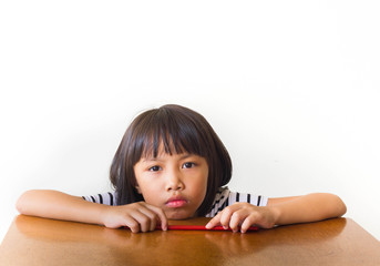 Bored children girl with red chopsticks sitting at the table