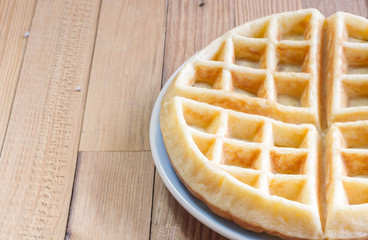 Full waffle with blue dish on the wooden background