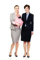 Two businesswomans with piggy bank.