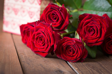 Bouquet of red roses on a dark wooden background.