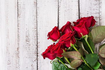 Bouquet of red roses on a light wooden background. Top view