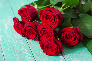 Bouquet of red roses on a light wooden background