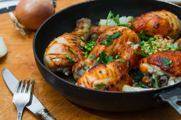 fried chicken drumsticks in a frying pan