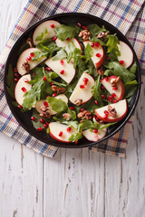 salad with apples, pomegranates, walnut and arugula. vertical top view

