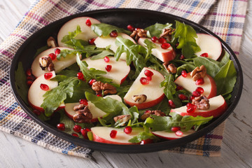 salad with apples, pomegranates and rocket close-up. horizontal
