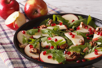 Fresh salad with apples, pomegranates, walnuts and arugula 
