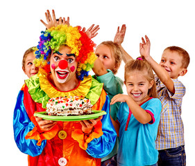 Clown holding cake on birthday with group children.