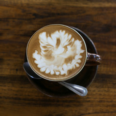 Hot art Latte Coffee in a cup on wooden table and Coffee shop bl