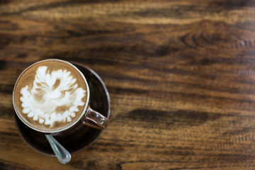 Hot art Latte Coffee in a cup on wooden table and Coffee shop bl