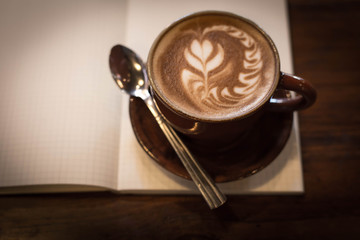 Coffee cup and notebook on grunge background