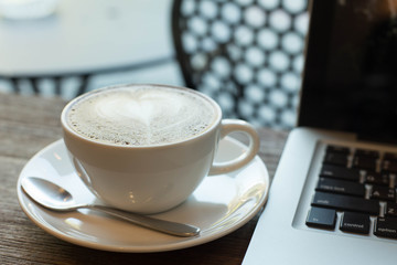 Hot art Latte Coffee in a cup on wooden table and Coffee shop bl