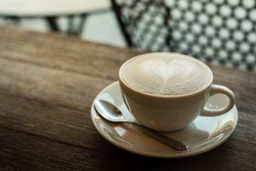 Hot art Latte Coffee in a cup on wooden table and Coffee shop bl