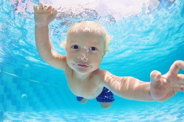 Funny face portrait of little baby boy swimming and diving underwater with fun in  pool. Active...