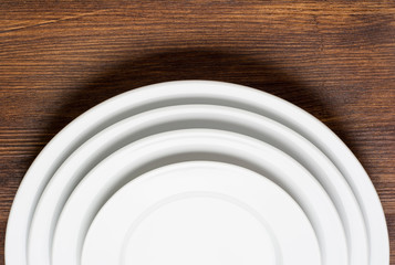 Empty white plates on wooden table