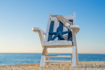 tropical beach with a sun-lounger facing the blue sea