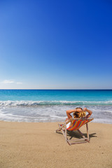 Obraz na płótnie Canvas Woman on a sun lounger at the beach