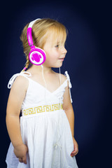 Beautiful little girl with headphones on her ears