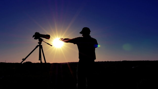 
Silhouette of  man  photographer  meditate  near camera with sun. 4K 3840x2160 
