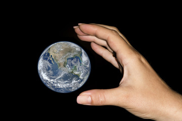 Hand catching the earth. Elements furnished by NASA