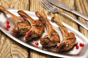 Roasted lamb ribs on an old metal plate