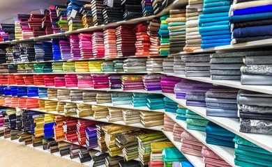 Foto auf Acrylglas Rolls of fabric and textiles in a factory shop or  store © _jure