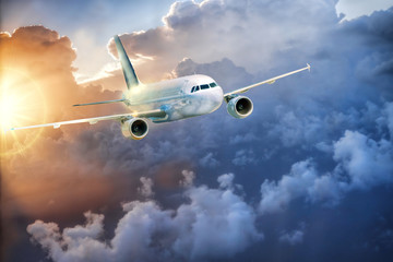 Obraz premium Airplane in the sky at amazing colorful sunset