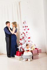 Christmas family of three  persons and fir tree with gift boxes 