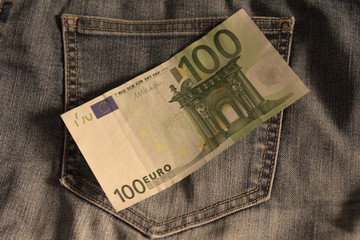 note of 100 euro over the detail if jeans