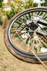 Naklejka premium Close up of a running bicycle rear wheel with details, chain and gearshift mechanism.