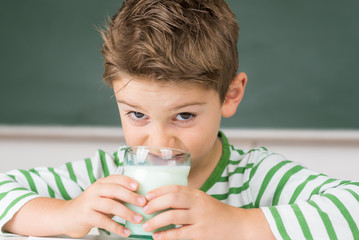 kind trinkt milch in der schule