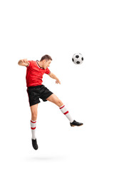 Fototapeta na wymiar Young football player heading a ball