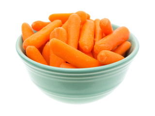 Small organic baby carrots in a green bowl