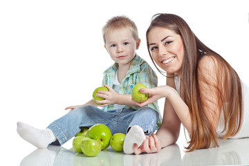 Fototapeta premium Mother with son are eating apples in studio