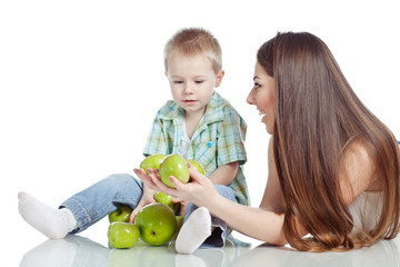 Mother with son are eating apples in studio