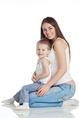 Happy mother are playing with her son in studio, white background 