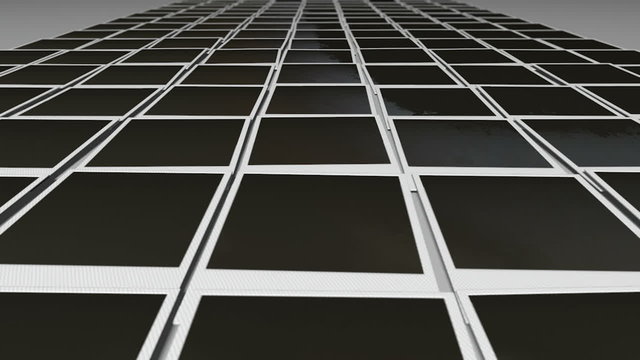An extreme closeup pan over a perspective view of a collection of many blank polaroid films laid out in rows on a blue background