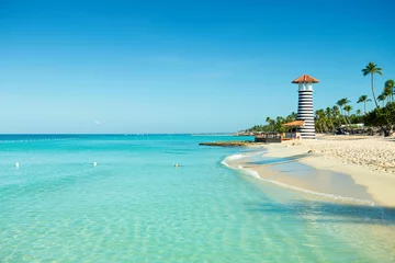  Paradijs Caribisch landschap. Heldere zee, wit zand, tropische palmbomen en vuurtoren aan zandstrand © Yarkovoy