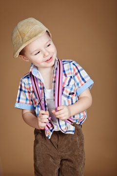 Stylish kid in studio, brown background