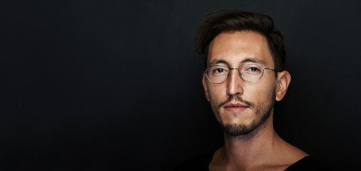 Portrait of handsome young man wearing glasses. Wide