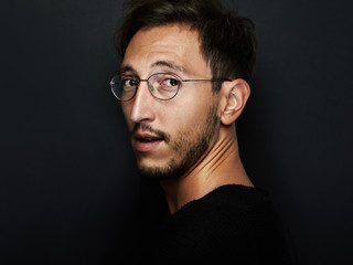Obraz premium Portrait of cute man wearing glasses and looks back. Horizontal
