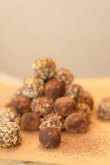 Pile of sweet chocolate bombs decorated in grated chocolate and chopped hazelnuts. Selective focus.
