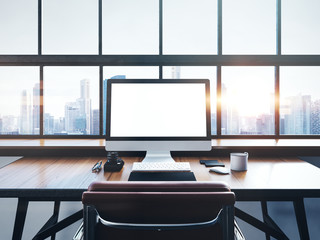 Photo of modern workspace with panoramic windows.  City at sunrise in the background. 3D rendering