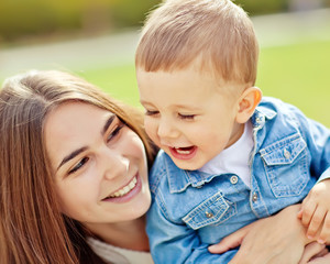 Happy mother are walking with her son in autumn park  