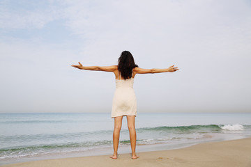 Fototapeta na wymiar beautiful woman standing on the shore of the beach