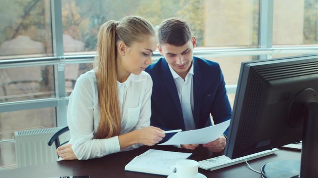 Success in business. Affiliates man and a woman reading good news on a computer screen, roughly rejoice, clap, laugh, hug