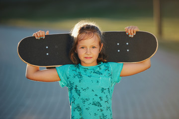 cute little girl with skateboard outdoors © Aliaksei Lasevich