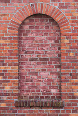 Arch in a wall made from red bricks