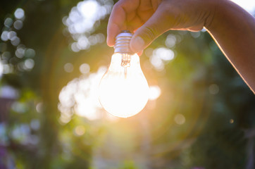 light bulb from sunset on hand concept